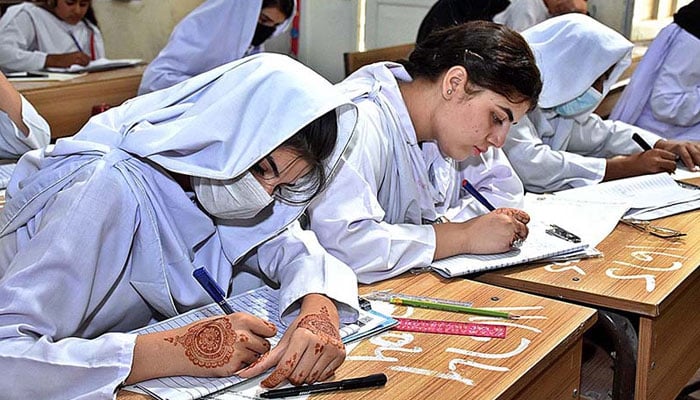 Students seen solving their papers during their annual examination of SSC (Part-II) 10th class at the Government Girls High School in Larkana on May 9, 2023. — APP