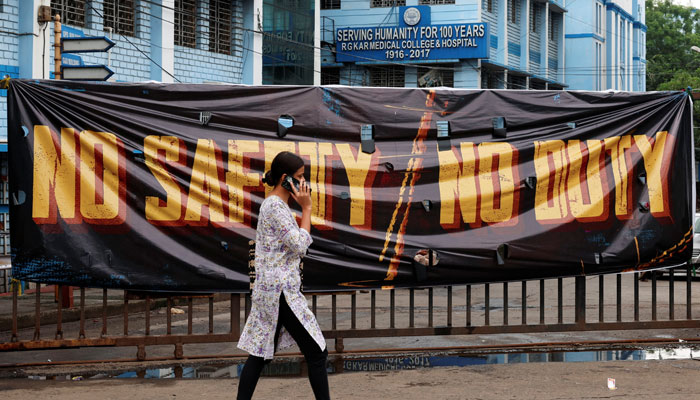 A woman walks past a closed gate of R G Kar Medical College and Hospital in Kolkata, India, August 19, 2024. — Reuters