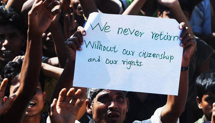 Above, a Rohingya refugee protests against a disputed repatriation program of stateless Muslims to Myanmar at the Unchiprang refugee camp near Teknaf on Nov. 15, 2018. — AFP