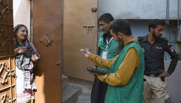 A Pakistan Bureau of Statistics official uses a digital device to collect information from a resident during door-to-door data collection at the first-ever digital national census in Karachi on March 28, 2023. — Online