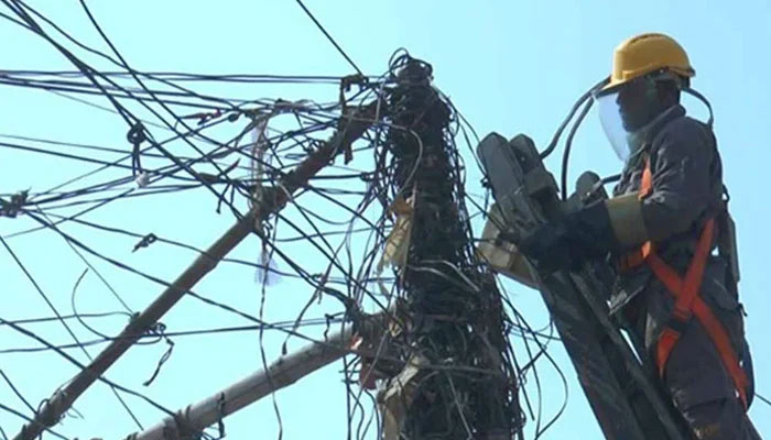 A representational image of showing a KE personnel working on power lines. — KE website/File