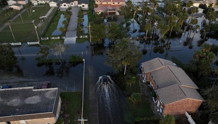 A drone view shows a car driving through a flooded street after Hurricane Milton made landfall in South Daytona, Florida, US, on October 11, 2024. — Reuters