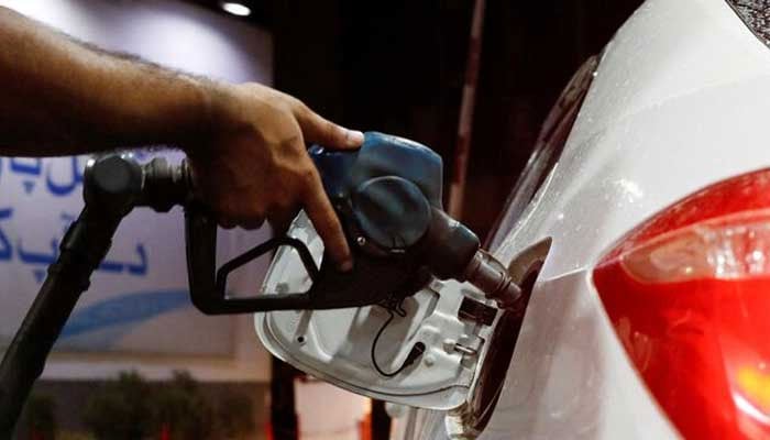 A worker holds a fuel nozzle to fills fuel in a car, after the government announced the increase of petrol and diesel prices, at petrol station in Karachi on September 16, 2023. — Reuters