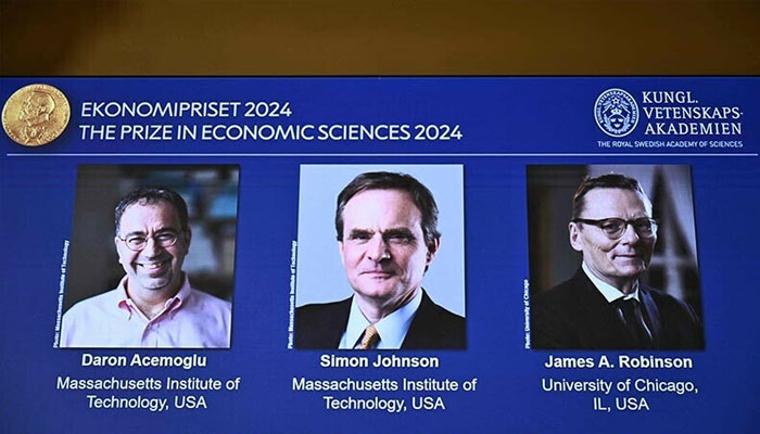 A screen shows the laureates (L-R) Turkish-American Daron Acemoglu and British-Americans Simon Johnson and James Robinson of the 2024 Sveriges Riksbank Prize in Economic Sciences in Memory of Alfred Nobel during the announcement by the Royal Swedish Academy of Sciences in Stockholm, Sweden on October 14, 2024. — AFP