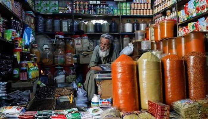 A shopkeeper waits for customers while selling spices and groceries items at the retail market in Karachi. — Reuters/File