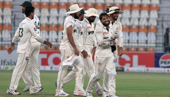 Pakistan players walk off at the end of the days play. — Reuters/file