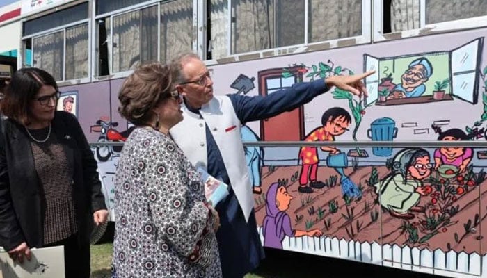 Australian High Commissioner Neil Hawkins with Pakistani cartoonist Nigar Nazar looking at her artwork on buses on October 14, 2024. — X/@GDiplomacyLens