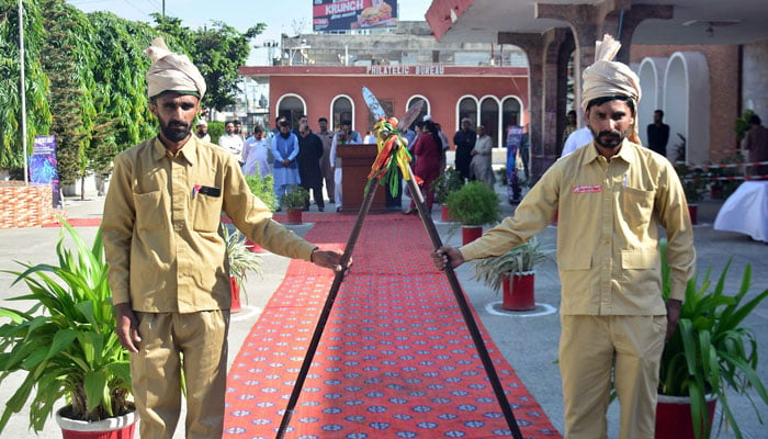 Postmen guard stands alert in traditional style during a ceremony on the eve of World Post Day, at the G.P.O office in Rawalpindi on October 9, 2024. — Online