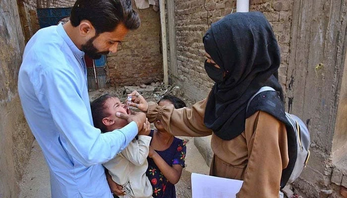 An image showing a health worker administering polio drops to a child during a polio vaccination campaign. — AFP/File