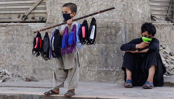 A representational image showing a child vendor selling face masks. — Reuters/File