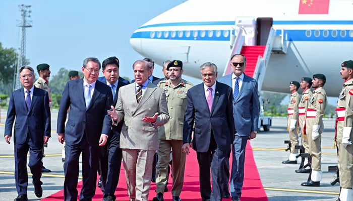 Pakistans Prime Minister Shehbaz Sharif welcomes Chinese Premier Li Qiang, upon his arrival to attend Shanghai Cooperation Organisation (SCO) meeting in Islamabad, Pakistan October 14, 2024. — PID