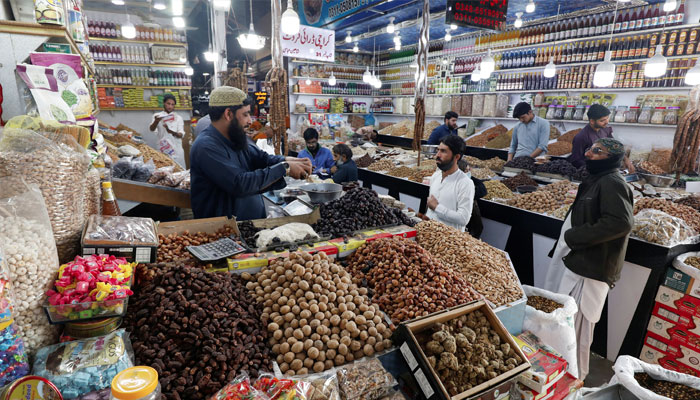 People buy dry fruits at a market in Karachi, Pakistan February 1, 2023. — Reuters