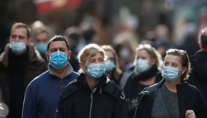 People walk in a street with masks on.— Reuters/file