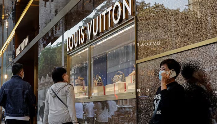 People walk past a Louis Vuitton store in Tsim Sha Tsui, a bustling shopping hotspot, in Hong Kong, China on December 5, 2023. — Reuters