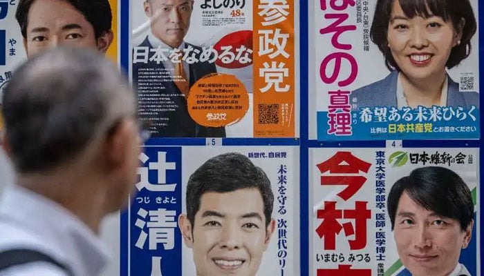 A man looks at campaign posters for the House of Representatives election in Tokyo on Oct. 15. — AFP/File