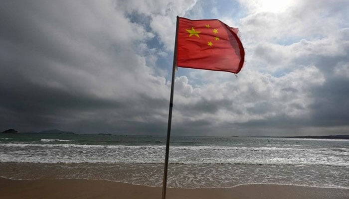 A Chinese flag flutters in the wind at a beach on Pingtan island, the closest point in China to Taiwan’s main island, in China’s Southeast Fujian province on October 15, 2024. — AFP/File