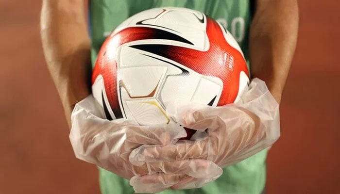 Ball boy wearing gloves holds a ball before a match. — AFP/file