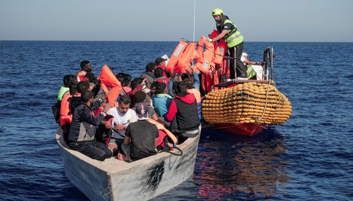 Crew members of NGO rescue ship Ocean Viking give lifejackets to migrants on an overcrowded boat in the Mediterranean Sea, October 25, 2022. — Reuters