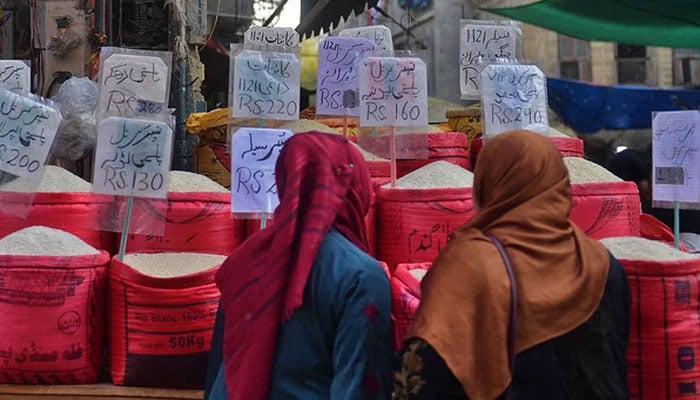 Women check rice prices at a main wholesale market in Karachi. — AFP/File