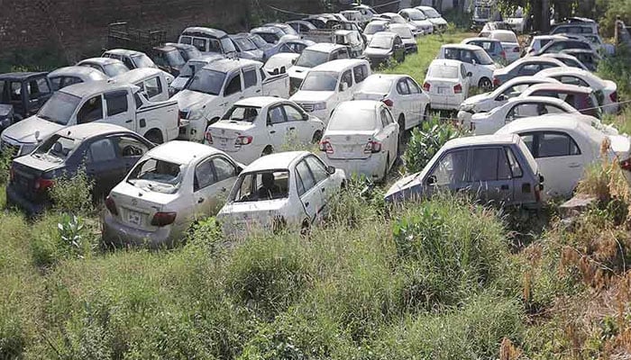 The image shows a backyard of a police station filled with impounded cars. — The News/Rahat Dar