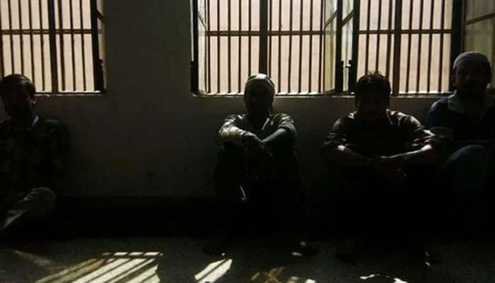 Representational image shows some inmates inside a dark lockup. — AFP/File