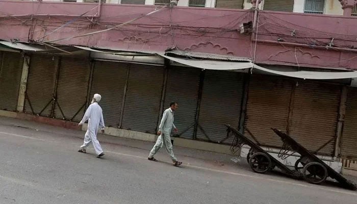 Representational image shows men walking along a closed market, during a shutter-down strike. — Reuters/File