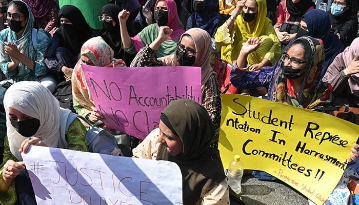 Students carry placards as they shout slogans during a protest in Lahore on October 15, 2024. — AFP