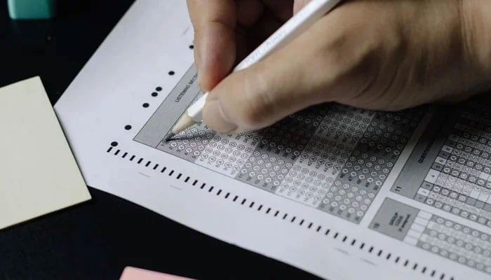 This representational image shows a person filling up a sheet during an examination. — Unsplash/File