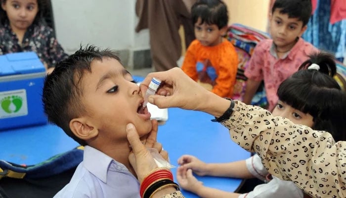 A leady health worker administering polio drops to a school student during polio eradication campaign in Hyderabad on April 29, 2024. — Online