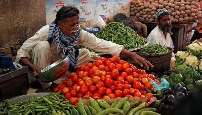 Men sell vegetables at their makeshift stalls at the Empress Market in Karachi, Pakistan. — Reuters/File