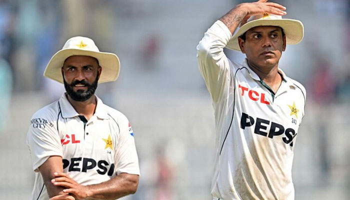 Pakistans Noman Ali (right) and Sajid Khan (left) walk back after winning the second Test cricket match against England at the Multan Cricket Stadium in Multan on October 18, 2024. — AFP