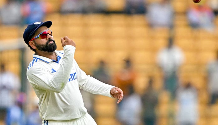 India´s captain Rohit Sharma tosses the ball during the fifth and final day of the first Test cricket match between India and New Zealand at the M. Chinnaswamy Stadium in Bengaluru on October 20, 2024. — AFP