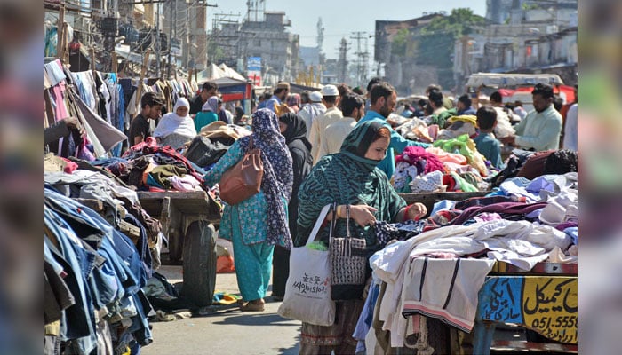 People buy secondhand clothes in the Jumma Bazaar in the Ganjmandi area in Rawalpindi on October 20, 2024. — Online