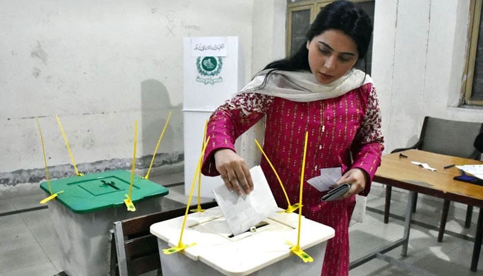 A voter casting her vote in a polling station in Lahore on February 8, 2024. — APP