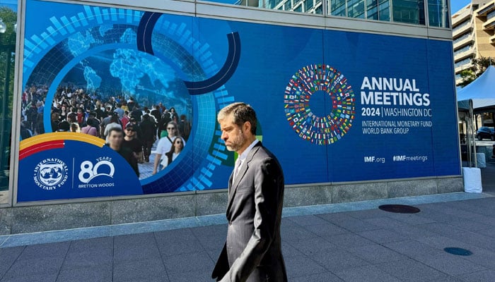 A man walks past signage for the 2024 Annual Meetings of the International Monetary Fund and the World Bank Group, outside of IMF headquarters, Washington, US, October 18, 2024. — AFP