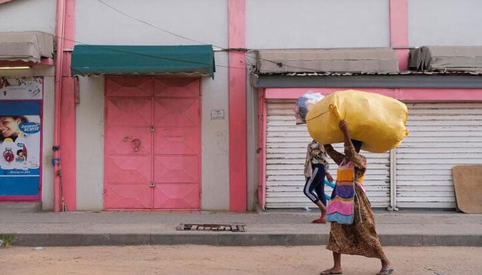 People walk in front of closed shops as traders lock up their stores in protest of Ghanas worsening economic conditions in Accra, Ghana October 19, 2022. — Reuters