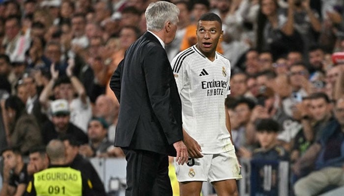 Real Madrid’s French forward Kylian Mbappe talks with Real Madrid’s Italian coach Carlo Ancelotti as he leaves the pitch during the Spanish league football match between Real Madrid CF and Deportivo Alaves at the Santiago Bernabeu stadium in Madrid on September 24, 2024. — AFP