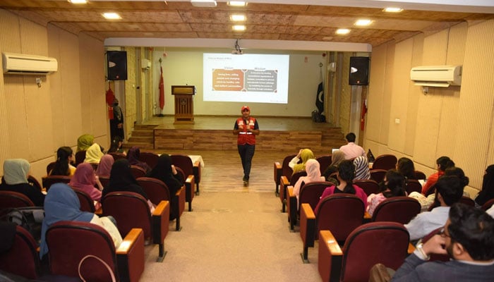 Participant speaks with attendees at a seminar on ‘Disaster Management’ organised by the NUML on October 21, 2024. — Facebook@NUMLOFFICIALPAGE