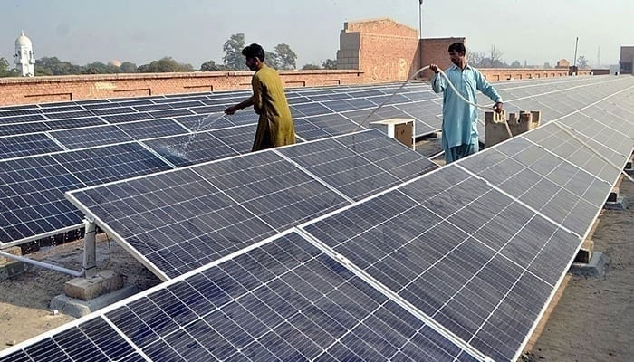 Representational image shows workers washing 300 KWP solar PV system in Multan, on December 4, 2022. — APP