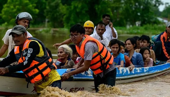 Flood-affected residents are transported on a rescue boat in Taungoo, Myanmars Bago region on September 14, 2024, following heavy rains in the aftermath of Typhoon Yagi. — AFP