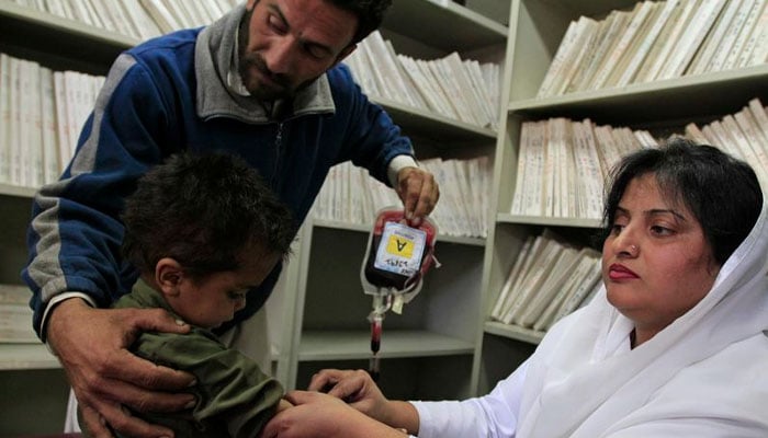 A hospital staff injects blood to a child suffering from Thalassaemia as he undergoes a blood transfusion process at Pakistan Institute of Medical Sciences (PIMS) in Islamabad December 5, 2014. — Reuters