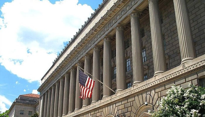 An American flag seen fluttering in front of a building.— LinkedIn@bureau-of-industry-and-security-u-s-department-of-commerce/file