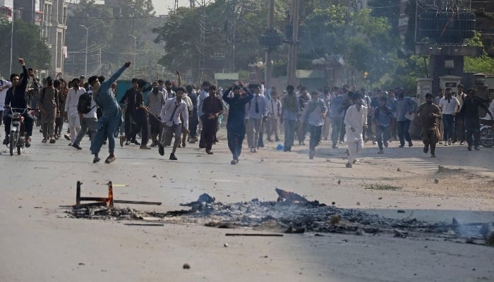 Students hurl stones towards security personnel during a demonstration to condemn the alleged rape of a female student in Rawalpindi on October 17, 2024. —AFP