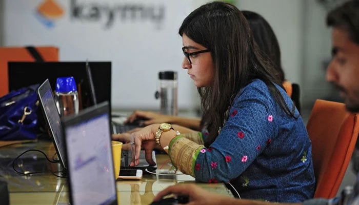 This representational image shows employees working in an office in Karachi. — AFP/File