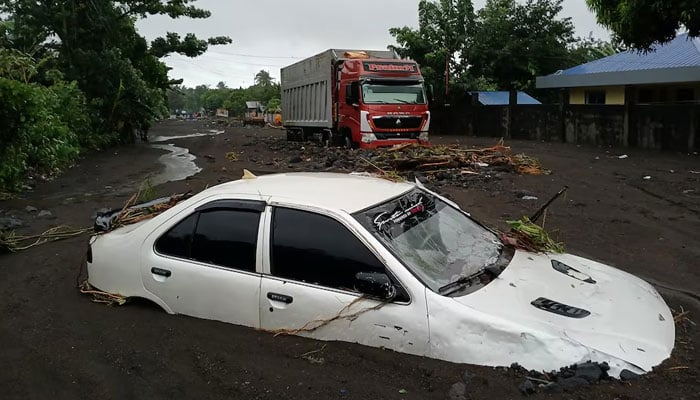 A vehicle is submerged on a street covered with mud due to heavy floods in the aftermath of Tropical Storm Trami on October 23, 2024. —Reuters