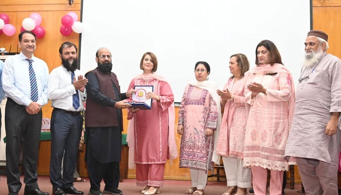 Vice Chancellor of FJMU Prof Dr Khalid Masood Gondal as a chief guest (3rd left) presents a shield to a participant at a seminar and walk on Breast Cancer Awareness at the Fatima Jinnah Medical University, Lahore on October 28, 2024. — Facebook@fjmuofficial