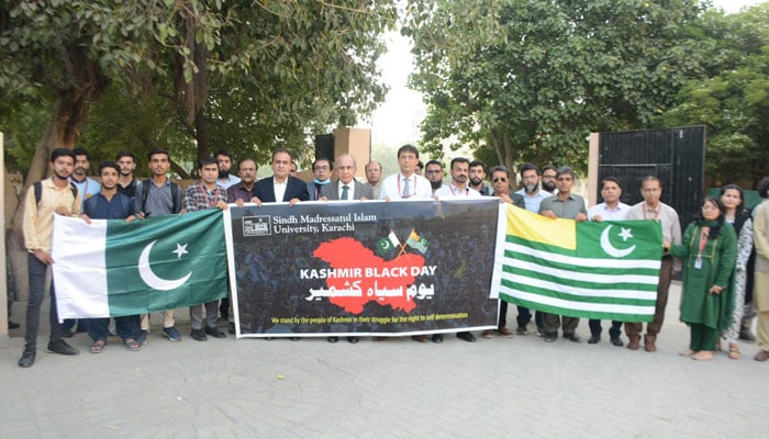 Vice Chancellor Dr Mujeeb Sahrai (centre) hold a banner in a rally to mark “Kashmir Black Day” and express solidarity with Kashmiris organised by the SMIU on October 27, 2024. — Facebook@smiu.edu.pk