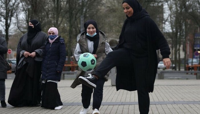 Supporters of the women soccer team “Les Hijabeuses” play soccer in front of the city hall in Lille as part of a protest as French Senate examines a bill featuring controversial hijab ban in competitive sports in France on February 16, 2022. — Reuters/File