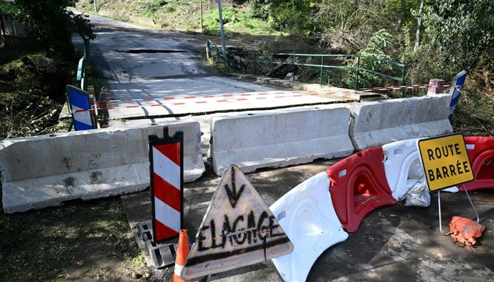 Barriers placed before a collapsed bridge due to a flood in a French village. —AFP/File