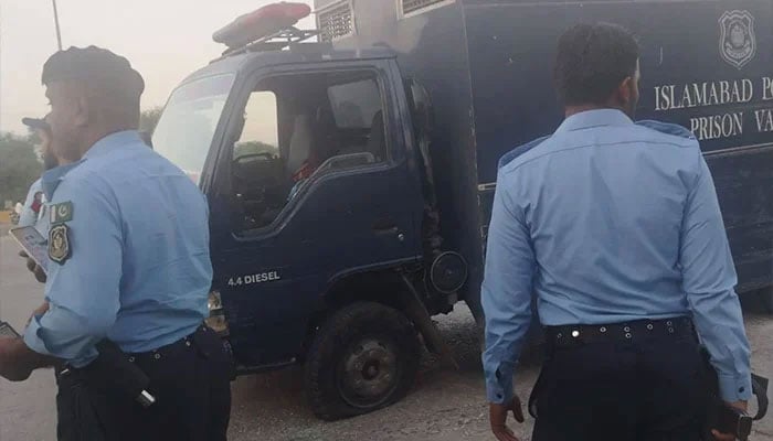 Islamabad Police officials standing beside the prison van following the armed attack by unidentified assailants at Sangjani Toll Plaza on October 25, 2024. — Reporters/Khalid Iqbal & Shakeel Anjum